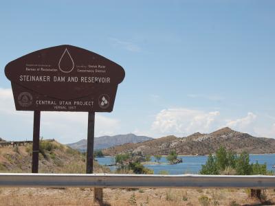 Steinaker Dam and Reservoir entrance sign with the reservoir and hills beyond