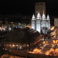 Temple Square in Salt Lake City lit for Christmas at night, with the Tabernacle dome and the Salt Lake Temple