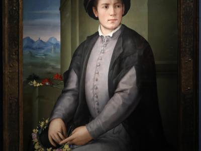A framed Renaissance-style portrait painting of a young man in a black cap and grey doublet, holding a floral wreath, set against a landscape background.
